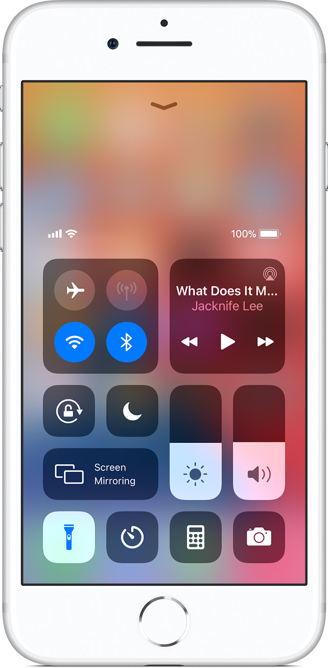 Пользователь iPhone выключает фонарик с помощью Пункта управления.