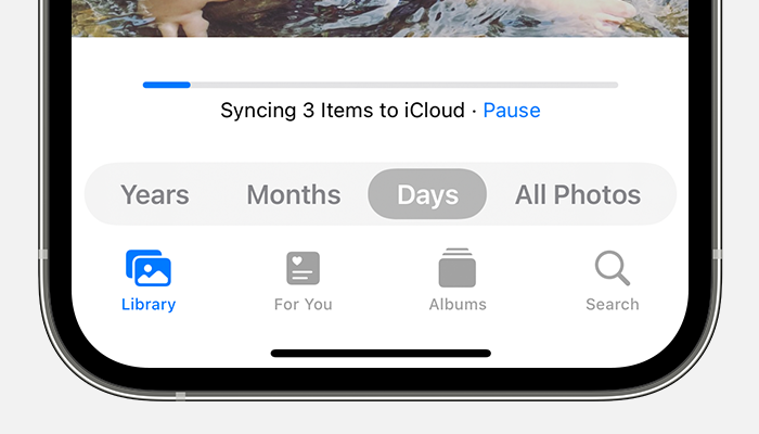 The status bar at the bottom of the Photos app shows that three items are syncing to iCloud.