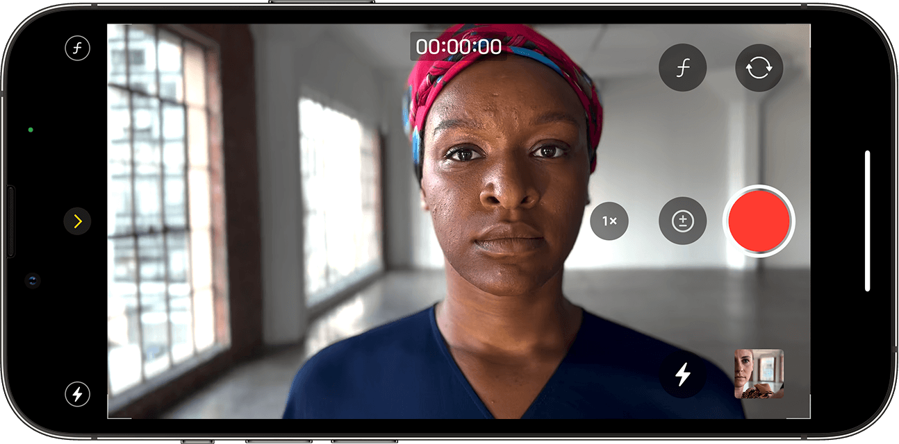 Pantalla de iPhone en la que se muestra la app Cámara en modo Video cinematográfico lista para grabar a una persona que está mirando a la cámara