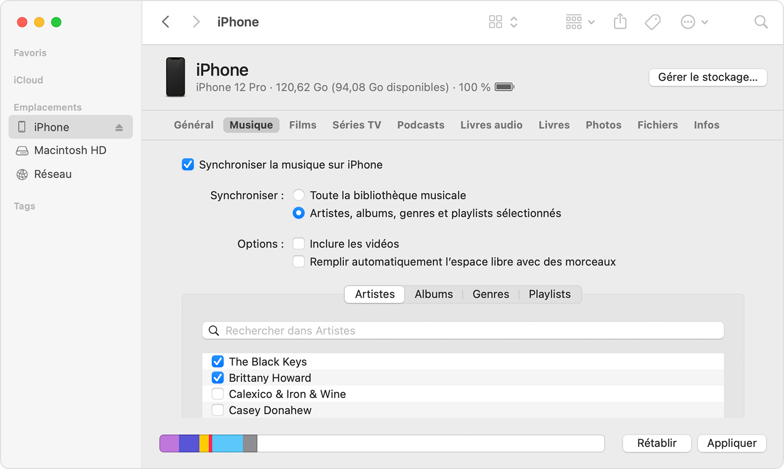 Une fenêtre du Finder affiche les options de synchronisation de la musique avec un iPhone connecté