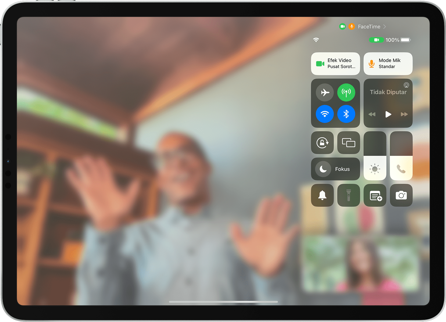 Layar iPad menampilkan panggilan FaceTime dengan Pusat Kontrol terlihat, termasuk tombol Efek Video