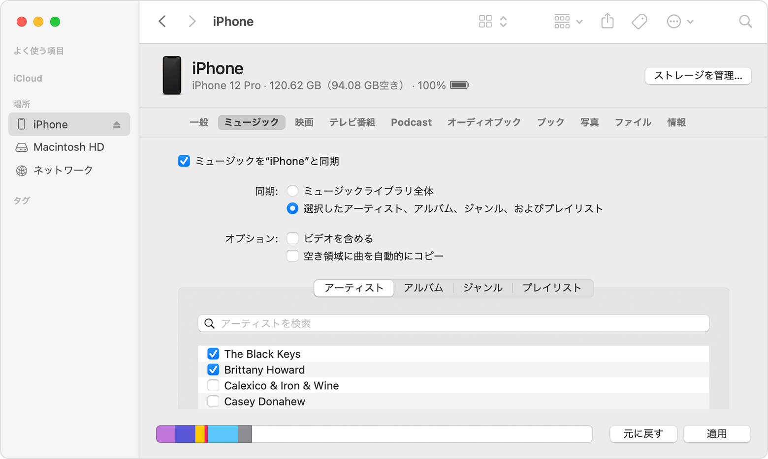 Finder のウインドウに、接続された iPhone との音楽の同期オプションが表示されているところ