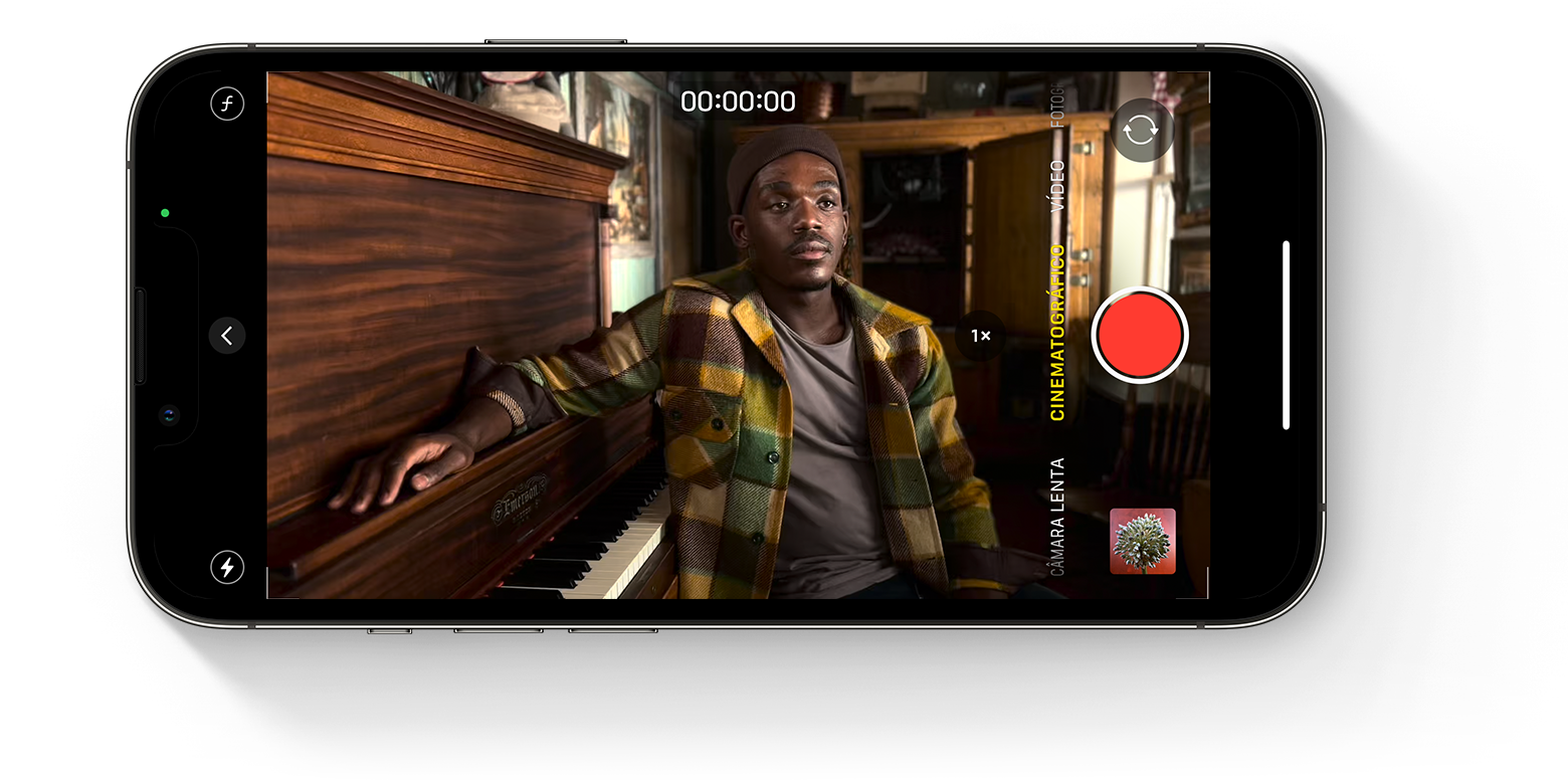 Ecrã do iPhone a mostrar a app Câmara no modo Vídeo cinematográfico com uma pessoa sentada a um piano